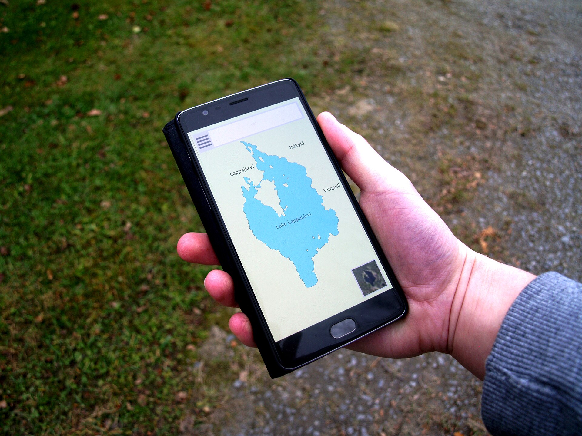 A hand holding a smartphone showing a map